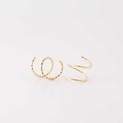 Minimal gold double hoop earrings with spiral twist design worn on ear, illusion of double piercing, diamond cut sterling silver jewelry