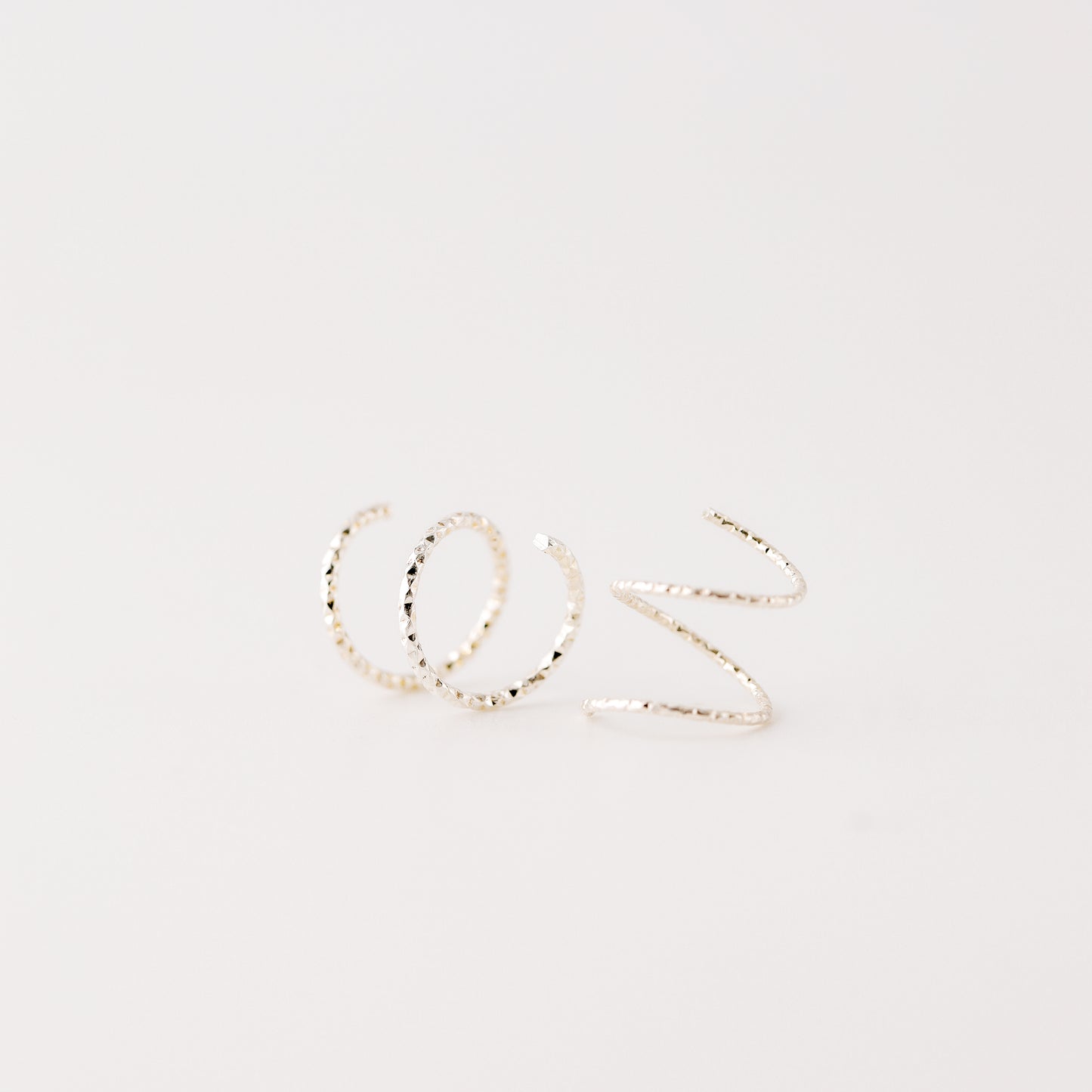 Minimal silver double hoop earrings on ear, tiny spiral earrings, sterling silver illusion double piercing jewelry