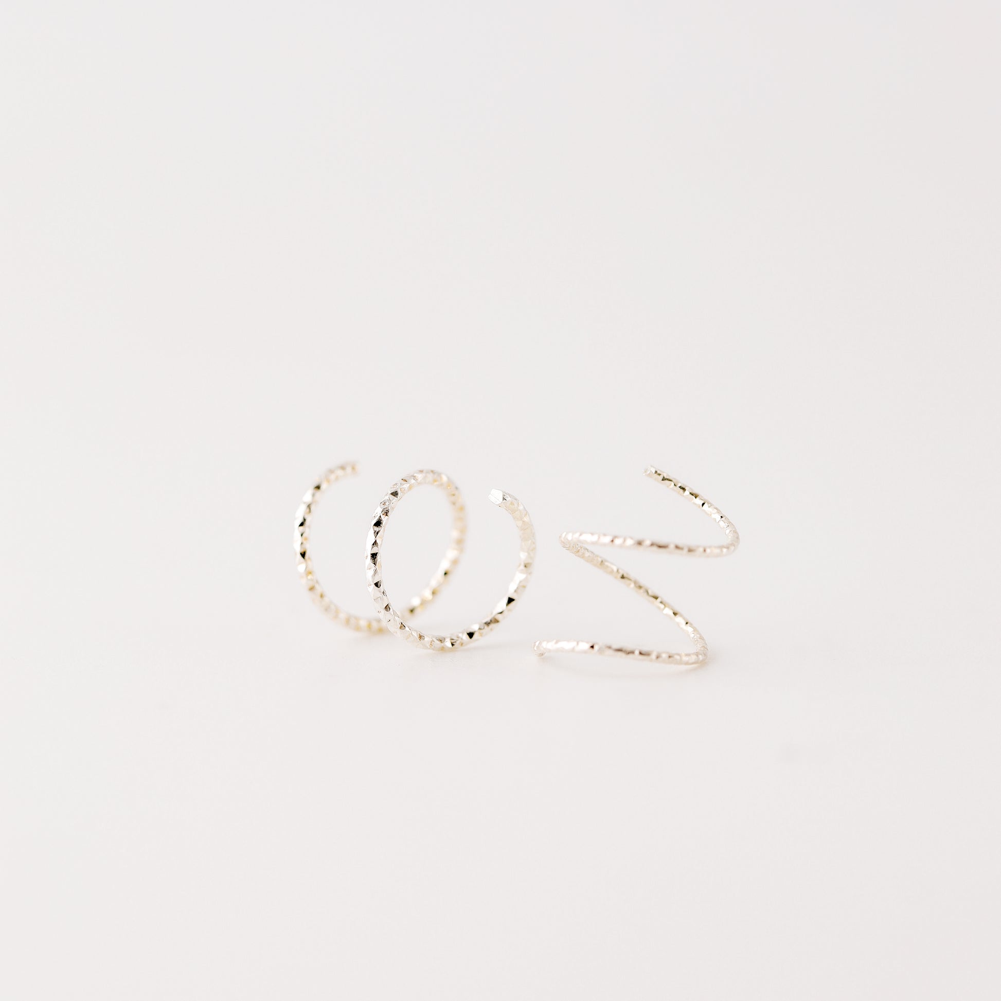 Minimal silver double hoop earrings on ear, tiny spiral earrings, sterling silver illusion double piercing jewelry