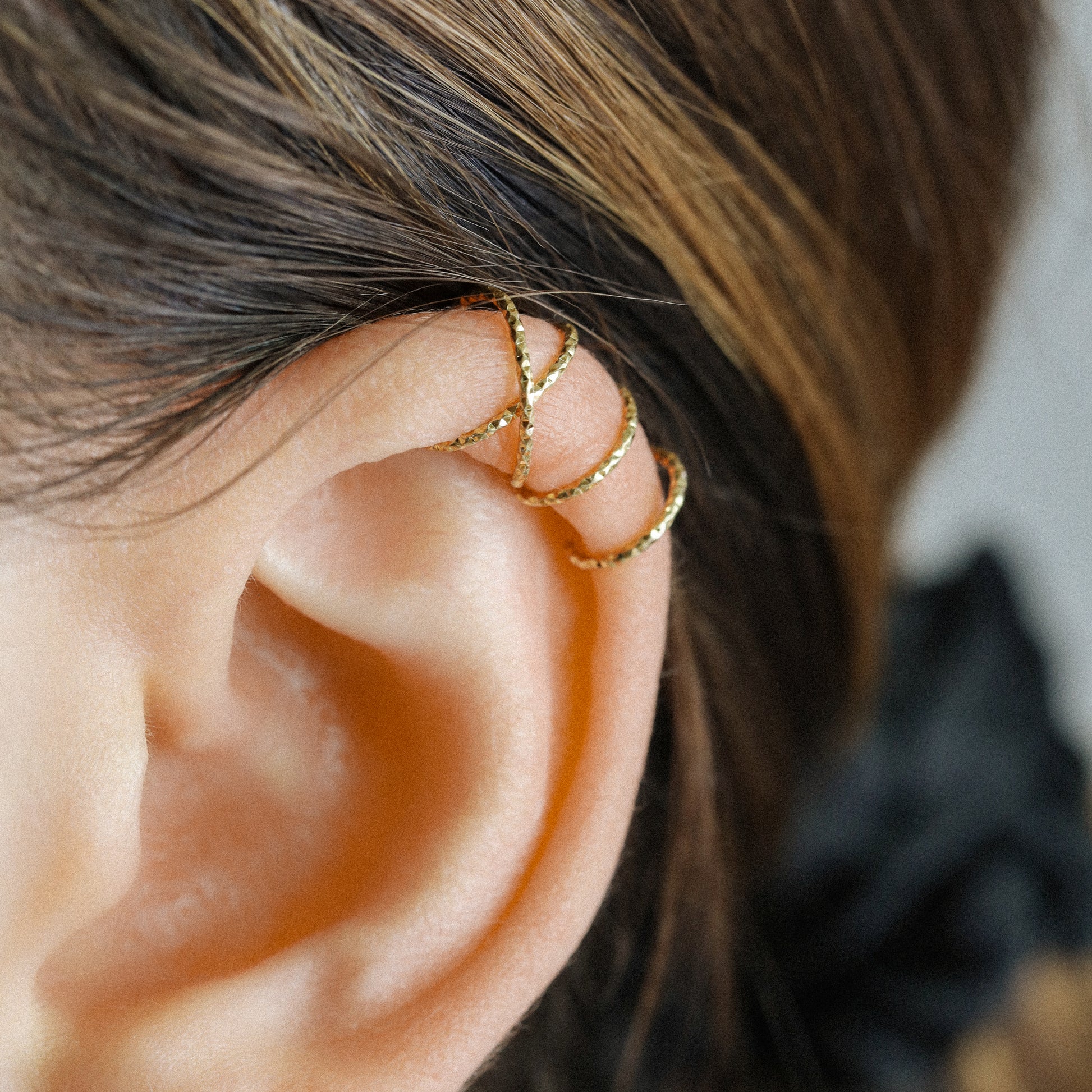 No-piercing double line and criss cross helix ear cuff worn on the upper ear, available in smooth and diamond cut finish options for cartilage styling.