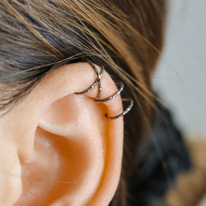 No-piercing double line and criss cross helix ear cuff shown on the upper ear, with smooth and diamond cut finish options for cartilage styling.