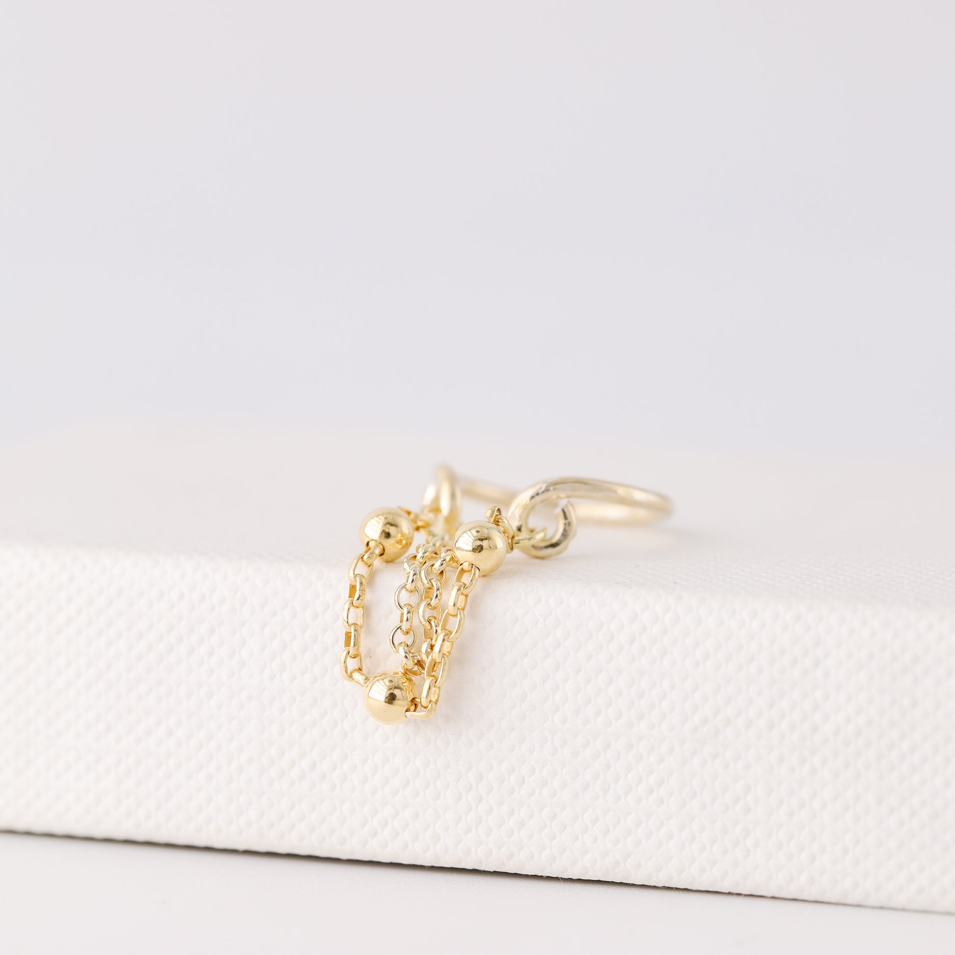 Gold beaded chain ear cuff worn on the conch with double draped chain detail