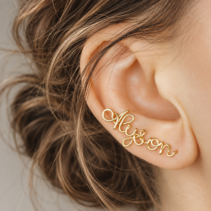 Handmade personalized name ear climber worn across the lobe through one standard piercing, featuring a custom flowing wire script design made with the chosen name or word up to 10 characters, available as a single left ear climber, single right ear climber or pair in solid 925 sterling silver, 14k gold filled and 14k rose gold filled.