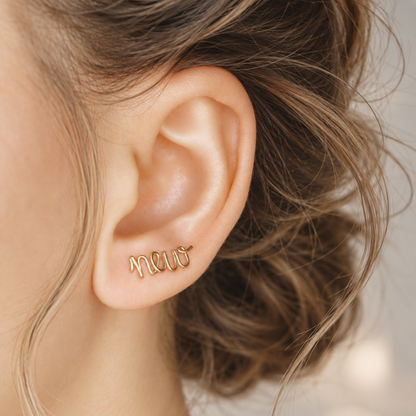 Handmade personalized name ear climber worn across the lobe through one standard piercing, featuring a custom flowing wire script design made with the chosen name or word up to 10 characters, available as a single left ear climber, single right ear climber or pair in solid 925 sterling silver, 14k gold filled and 14k rose gold filled.