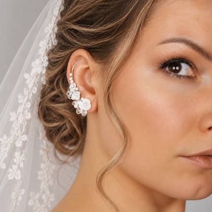 Bridal ear crawler worn with a formal updo and veil, decorated with genuine freshwater pearls, luminous flower shapes and clear crystal briolettes for a detailed wedding look.