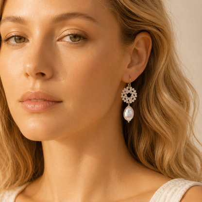 Close-up of a woman wearing a gold-plated baroque pearl drop earring with a delicate white crystal wreath, showcasing its elegant bohemian style.