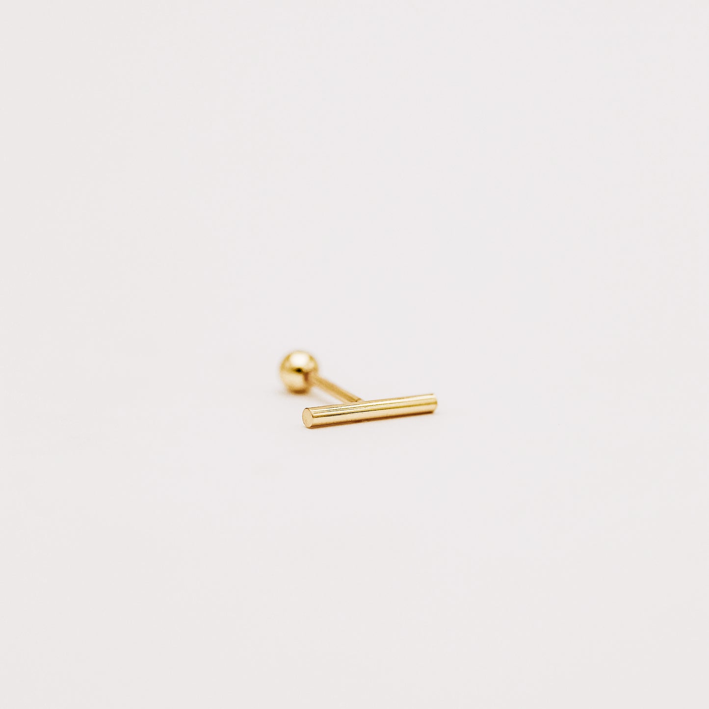 Side view of gold bar screw back earring showing slim minimalist profile