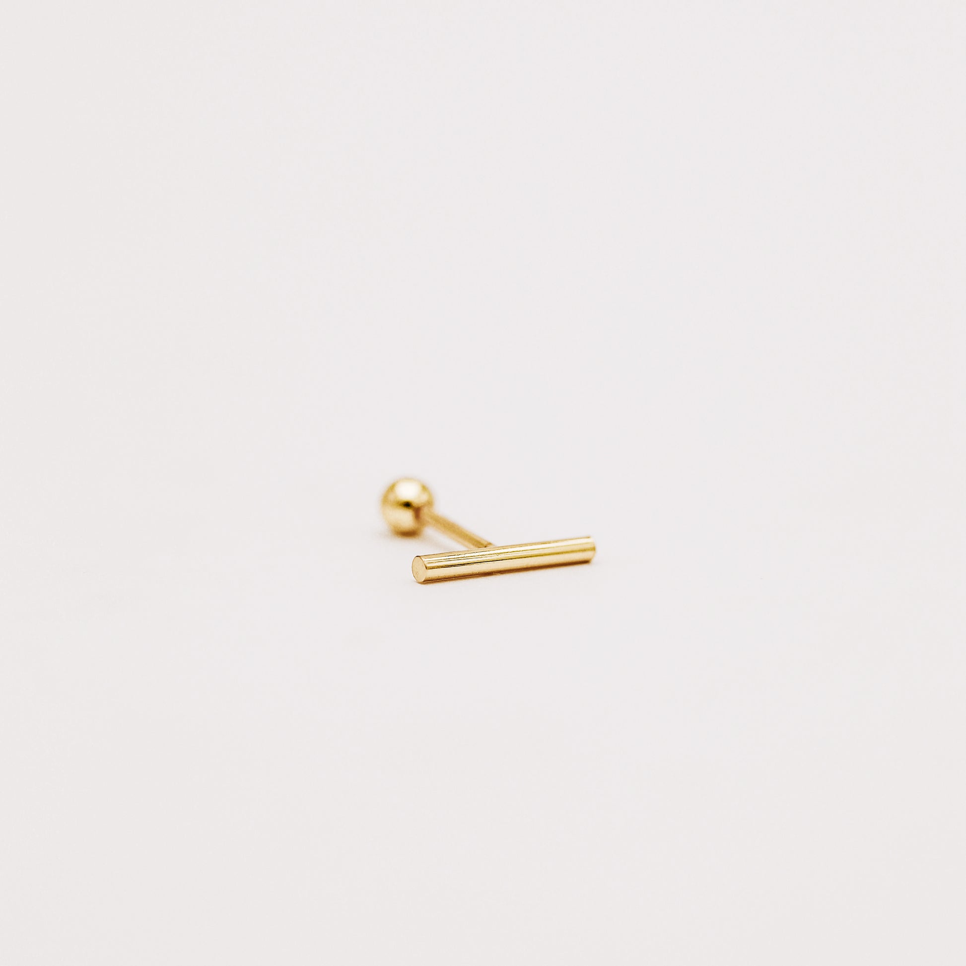 Side view of gold bar screw back earring showing slim minimalist profile