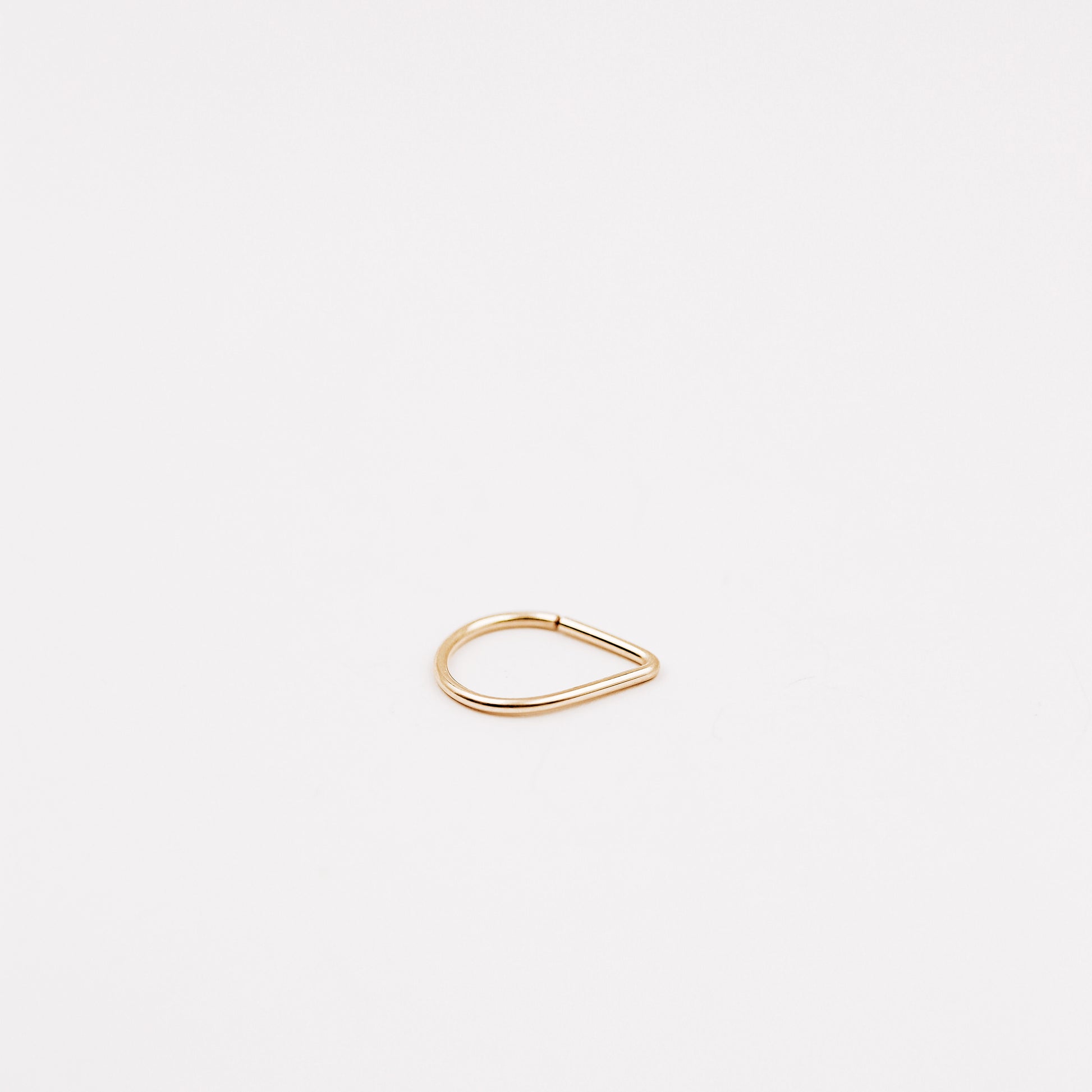 Gold filled chevron septum ring with open hoop design on a clean white background.