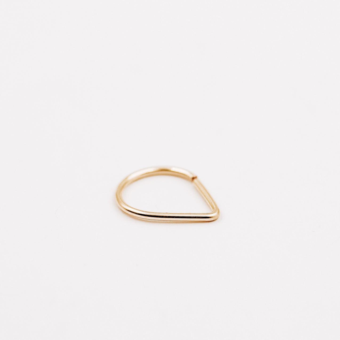 Gold filled chevron septum ring with open hoop design on a clean white background.