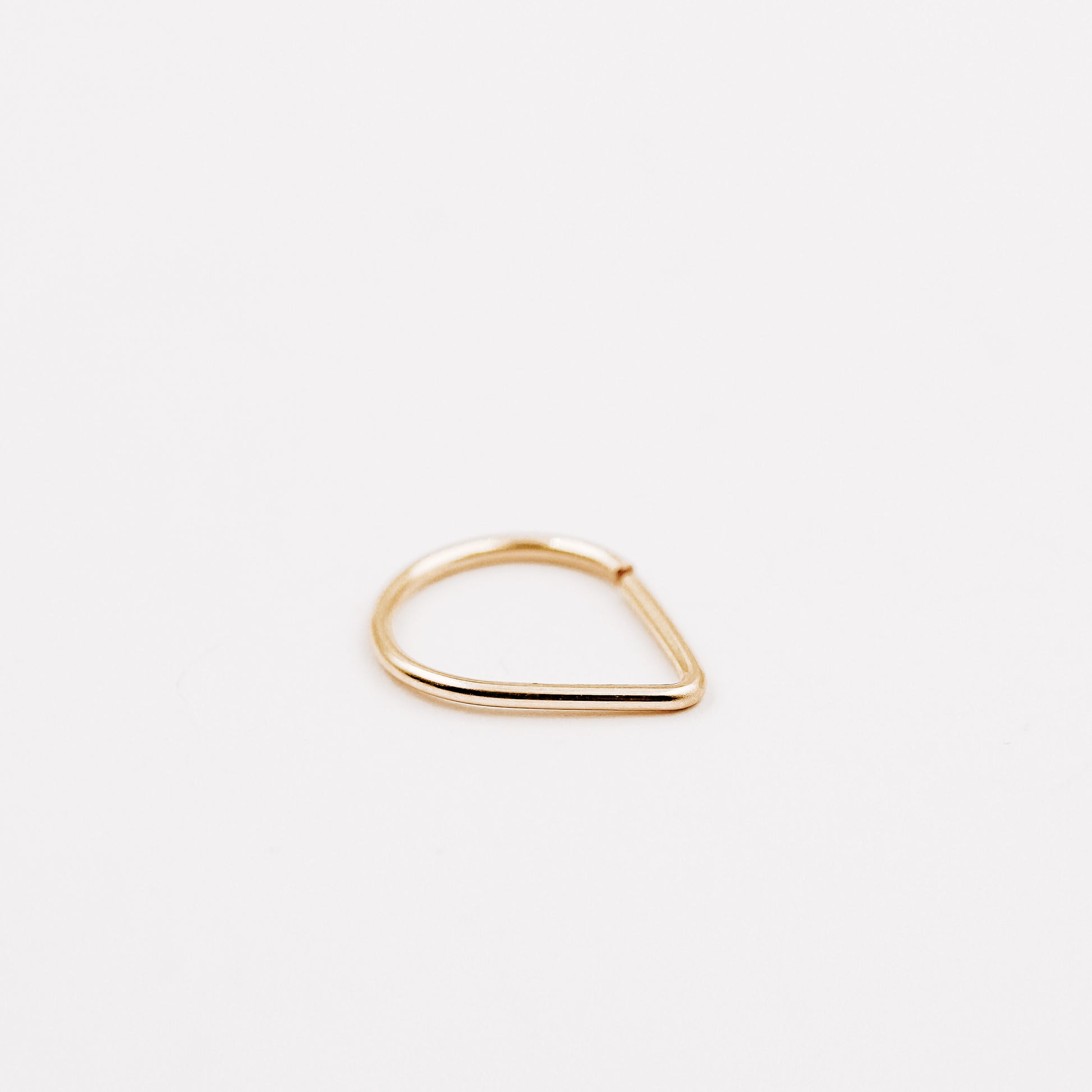 Gold filled chevron septum ring with open hoop design on a clean white background.