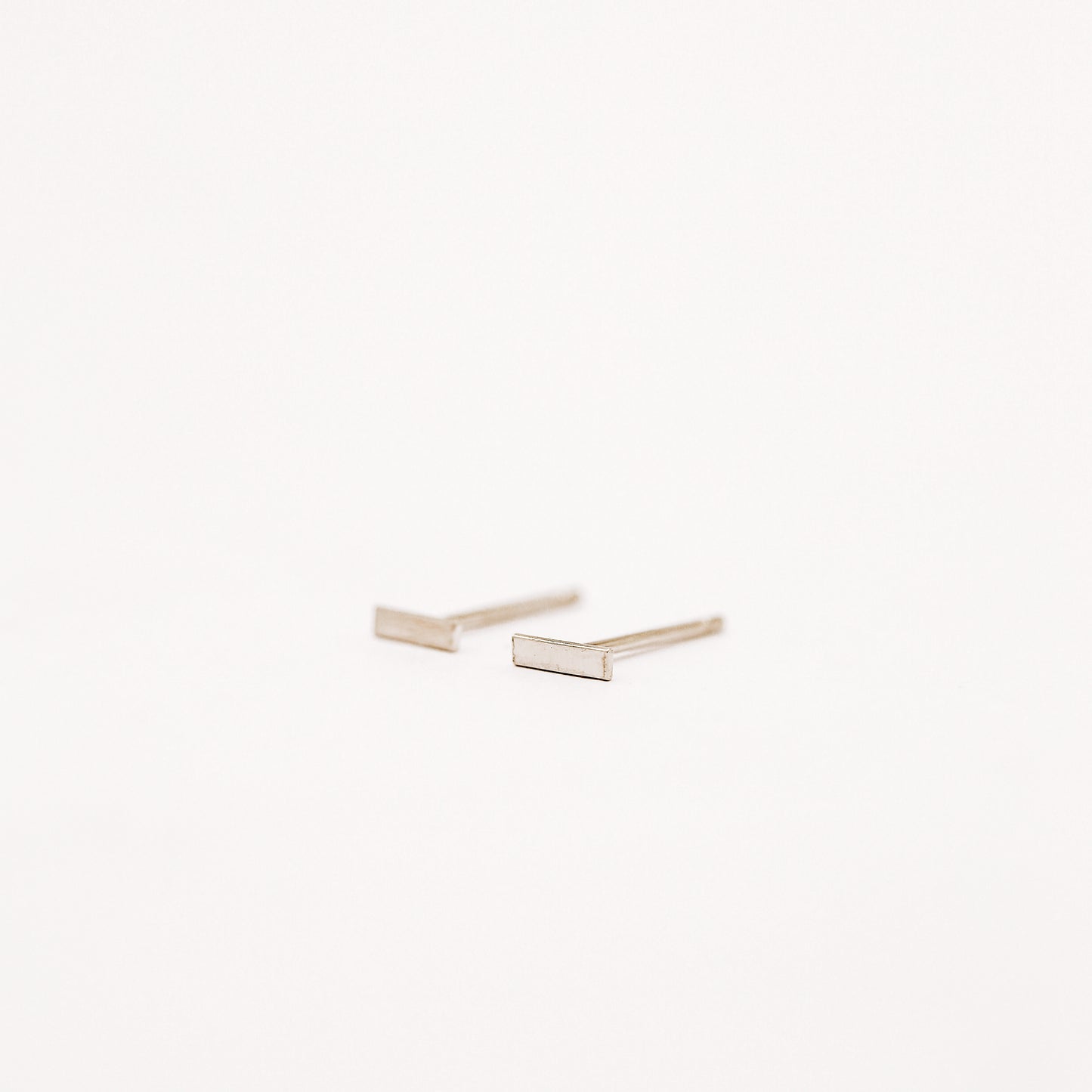 Tiny rectangle bar stud earrings in solid 925 sterling silver on white background