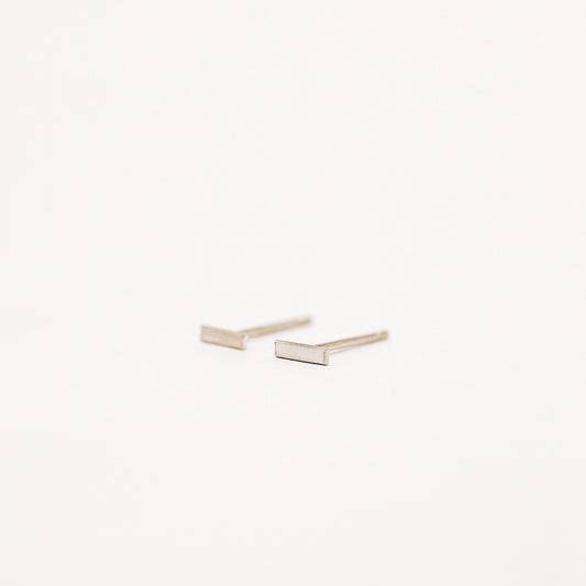 Tiny rectangle bar stud earrings in solid 925 sterling silver on white background