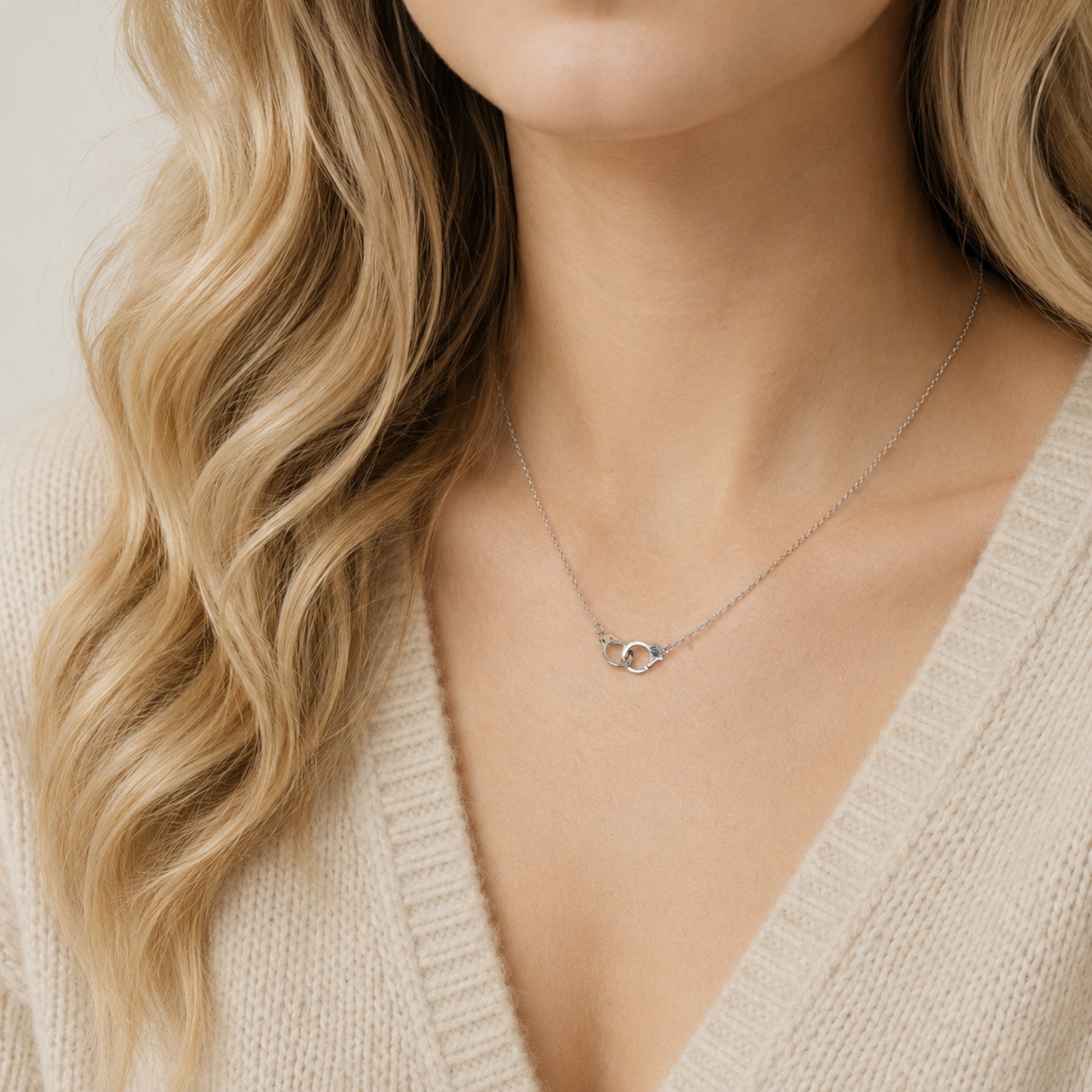 Dainty handcuff necklace worn by model with beige knit sweater