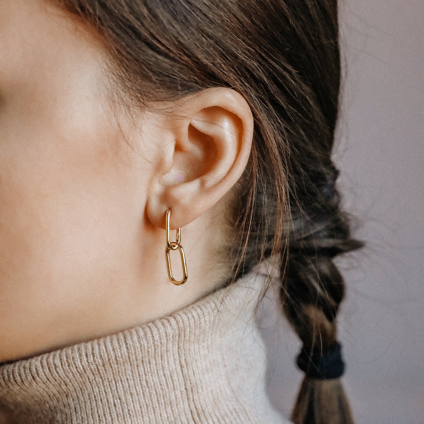 Close up of gold double open-link earrings with polished geometric silhouette
