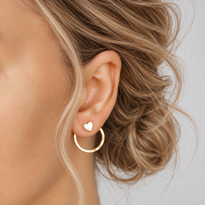 Gold round ear jacket worn with a white heart stud at the front, demonstrating how the same jacket can be styled with different stud designs.