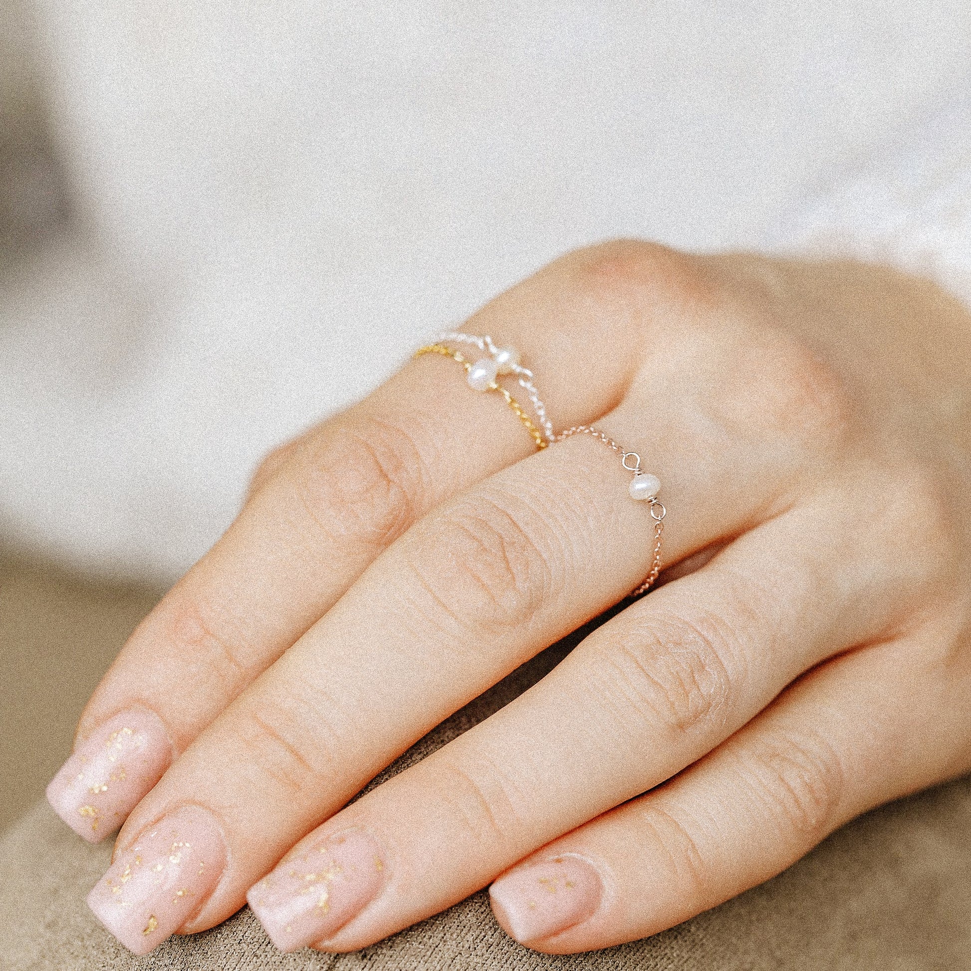 Pearl chain ring in silver and gold tones styled on fingers