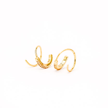 Lightweight gold twist hoop earring worn on ear
