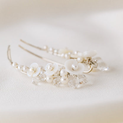 Pair of floral pearl ear climbers displayed on soft white silk background