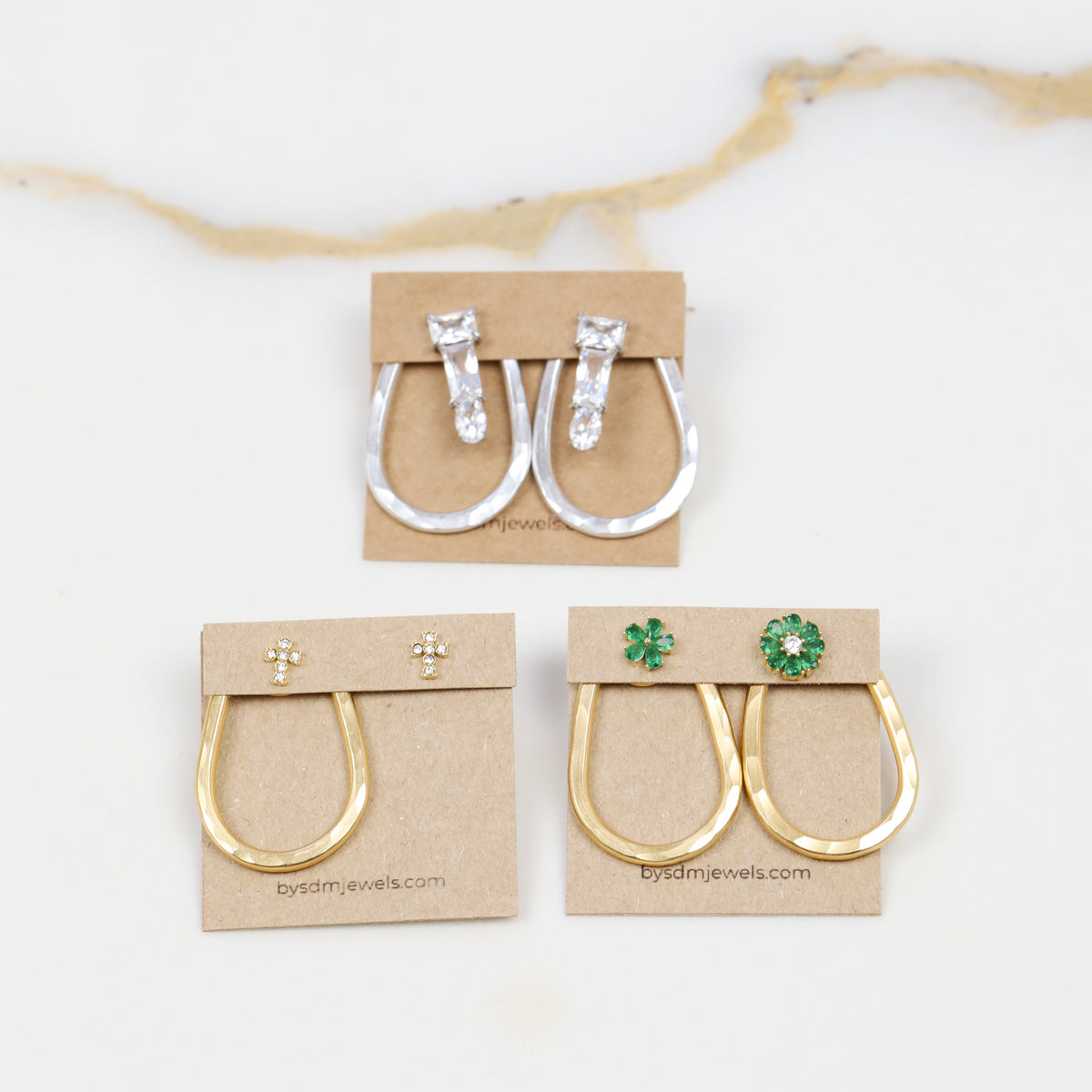 Selection of gold and silver teardrop ear jacket backs displayed with different stud styles to illustrate possible styling combinations.