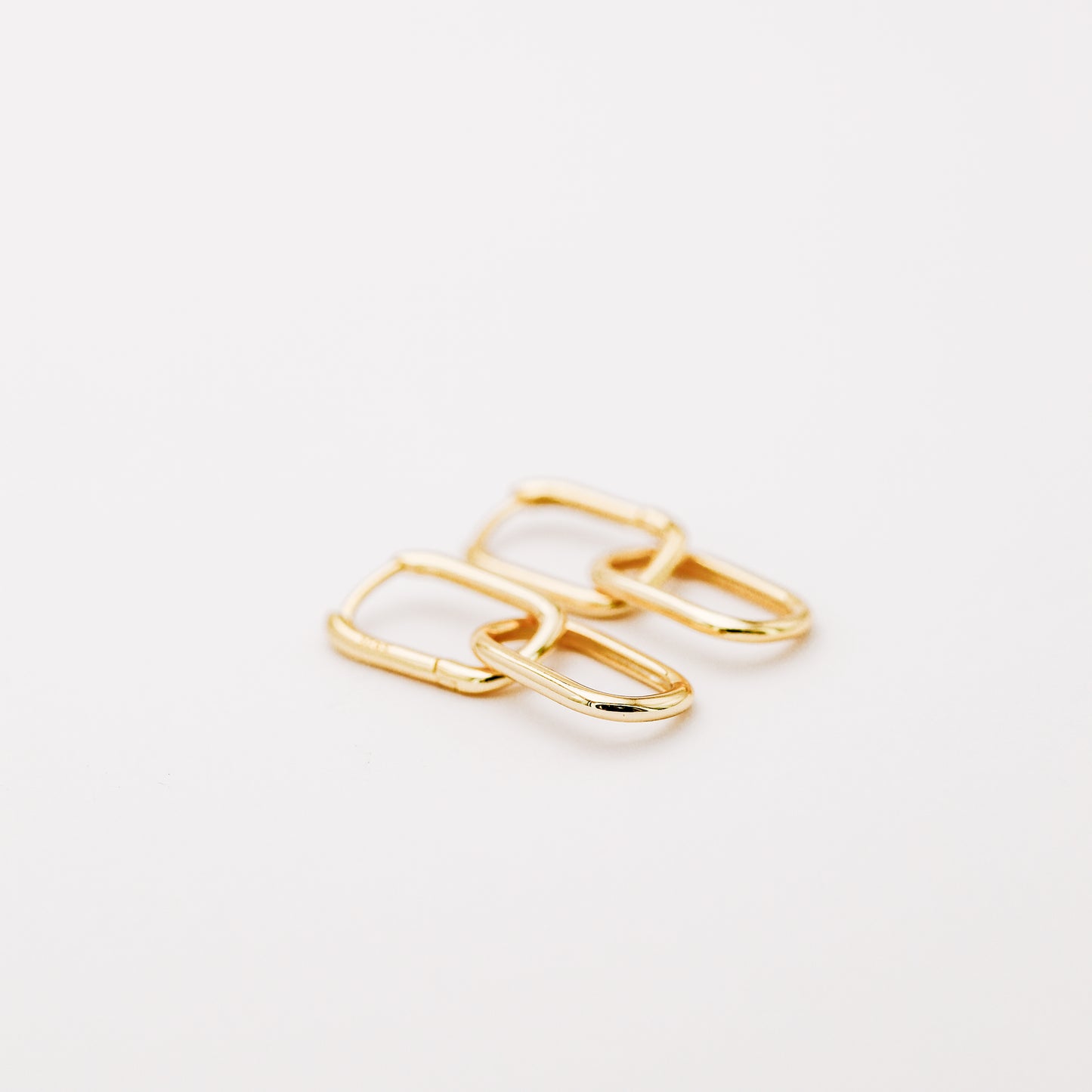 Pair of gold double open-link hoop earrings displayed on white background