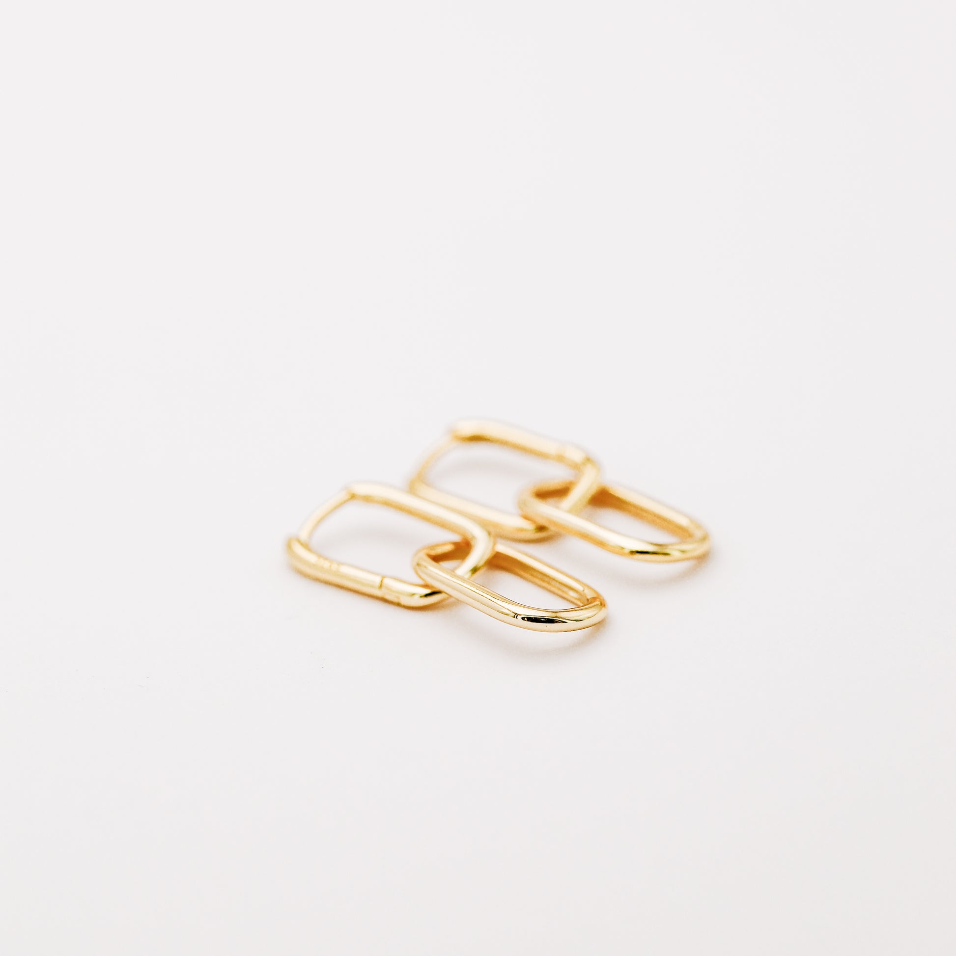 Pair of gold double open-link hoop earrings displayed on white background