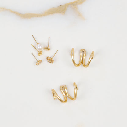 Two gold handmade double loop Ear Jacket backs displayed separately with assorted stud earrings, highlighting the flowing hand-shaped curves.