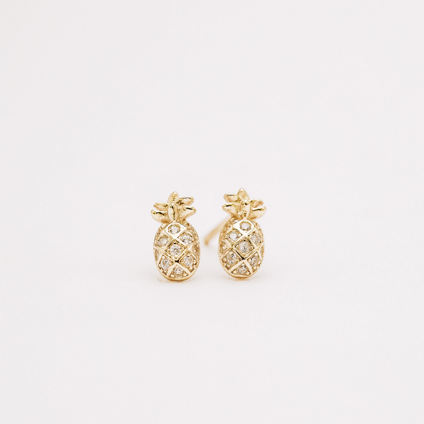 Small pineapple stud earrings with cubic zirconia on white background