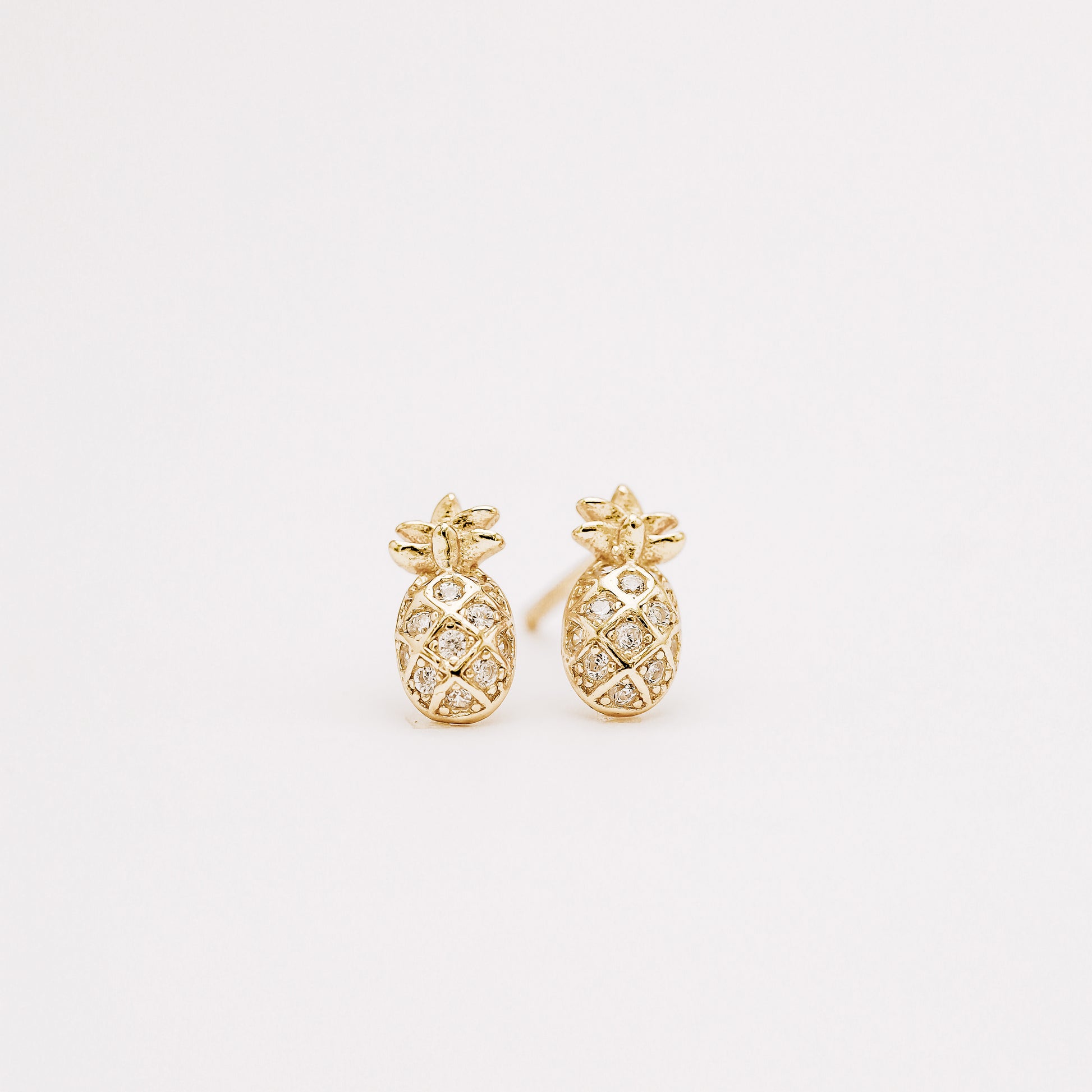Small pineapple stud earrings with cubic zirconia on white background