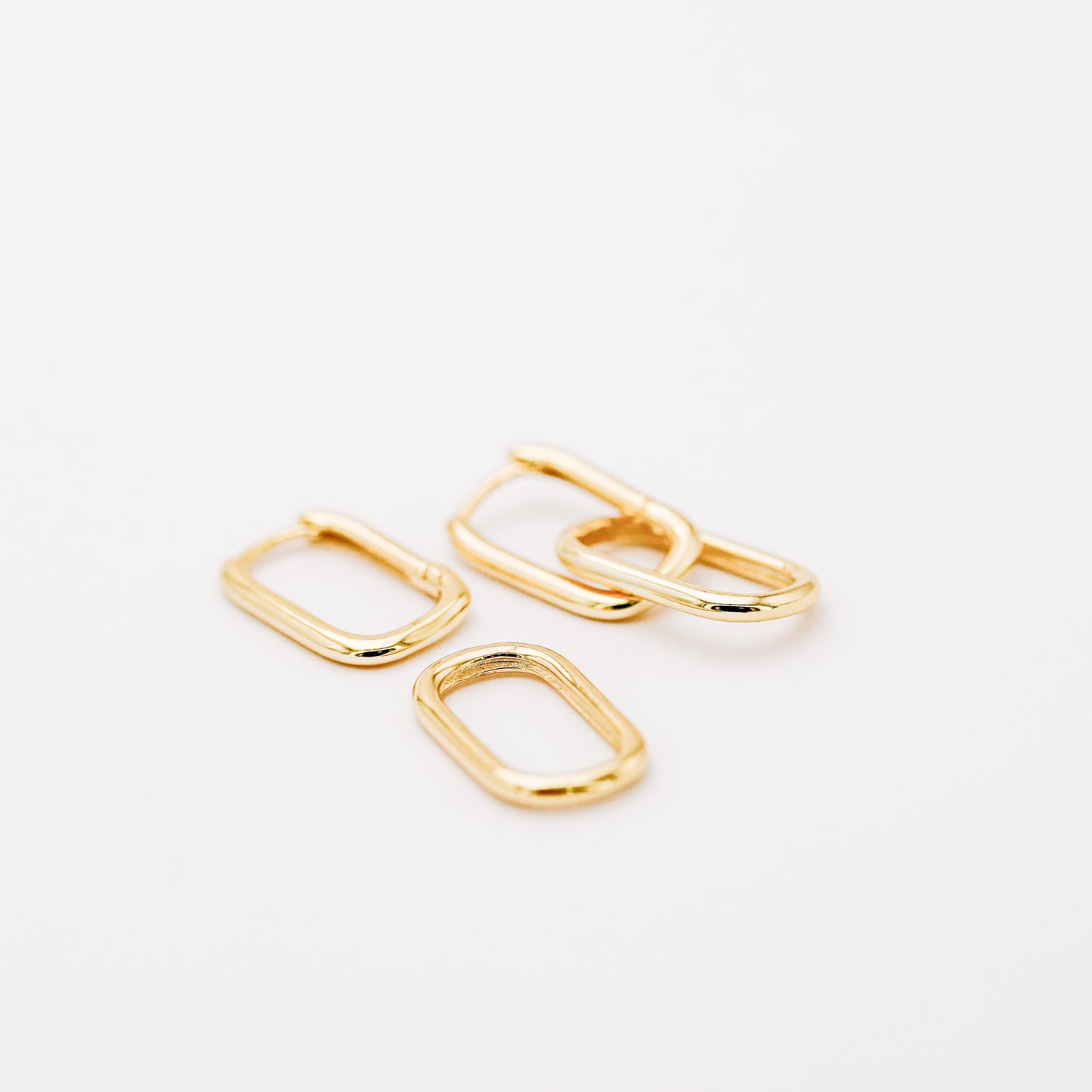 Gold hinged hoop earrings showing the polished double link construction