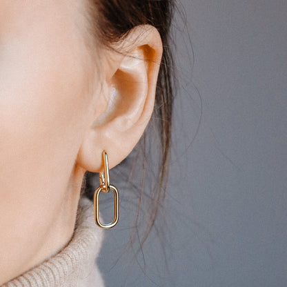 Side view of gold double open-link hinged hoop earring worn on ear