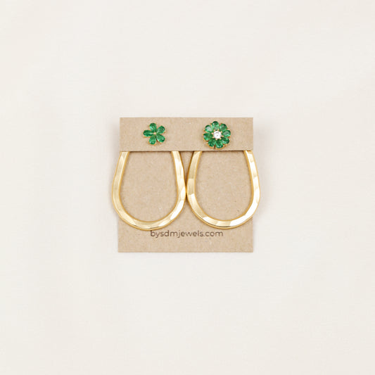 Matching pair of gold hammered teardrop ear jackets displayed with decorative green studs on a jewelry card.