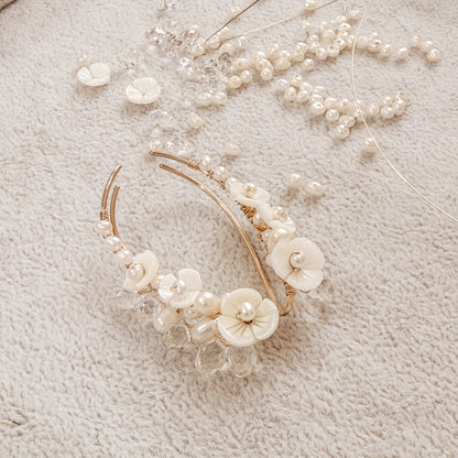 Handmade pearl flower ear climbers displayed on neutral fabric with scattered pearls