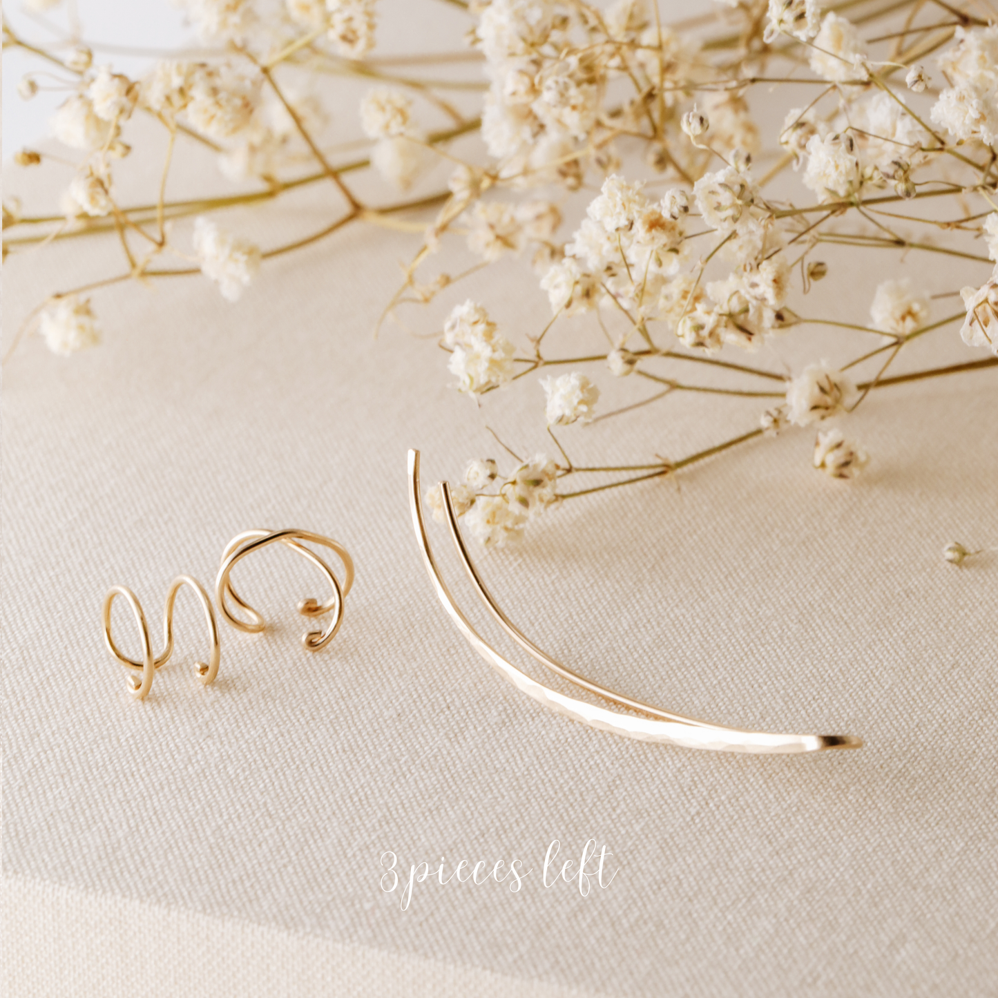 3 pieces left ear climber set displayed on beige fabric with dried white flowers, featuring one long hammered ear climber for the left ear, one Double Line no-piercing helix cuff and one Criss-Cross no-piercing helix cuff in a warm gold finish.