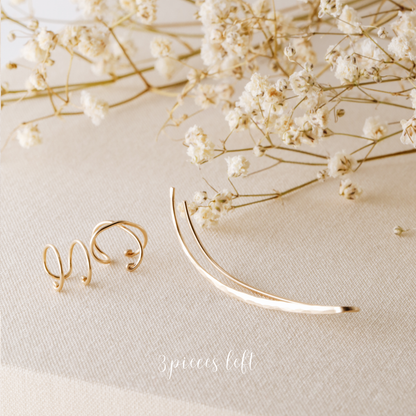 3 pieces left ear climber set displayed on beige fabric with dried white flowers, featuring one long hammered ear climber for the left ear, one Double Line no-piercing helix cuff and one Criss-Cross no-piercing helix cuff in a warm gold finish.