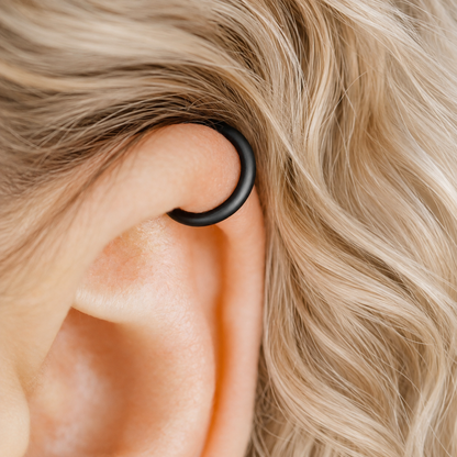 Thick smooth no-piercing ear cuff shown worn on different areas of the ear, including lobe, conch, cartilage and upper helix, with a rounded wrap design available in sterling silver, 18k yellow gold plated sterling silver, 18k rose gold plated sterling silver and black aluminum.