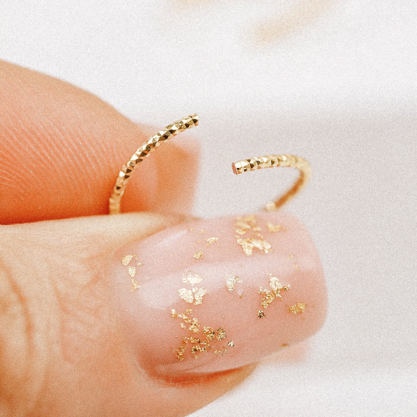 Illustration showing how to correctly twist open a rose gold endless hoop earring without a hinge.