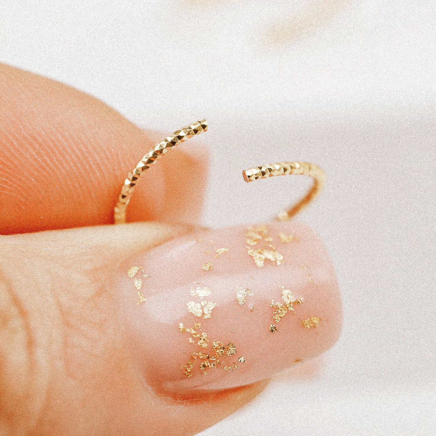 Illustration showing how to correctly twist open a rose gold endless hoop earring without a hinge.