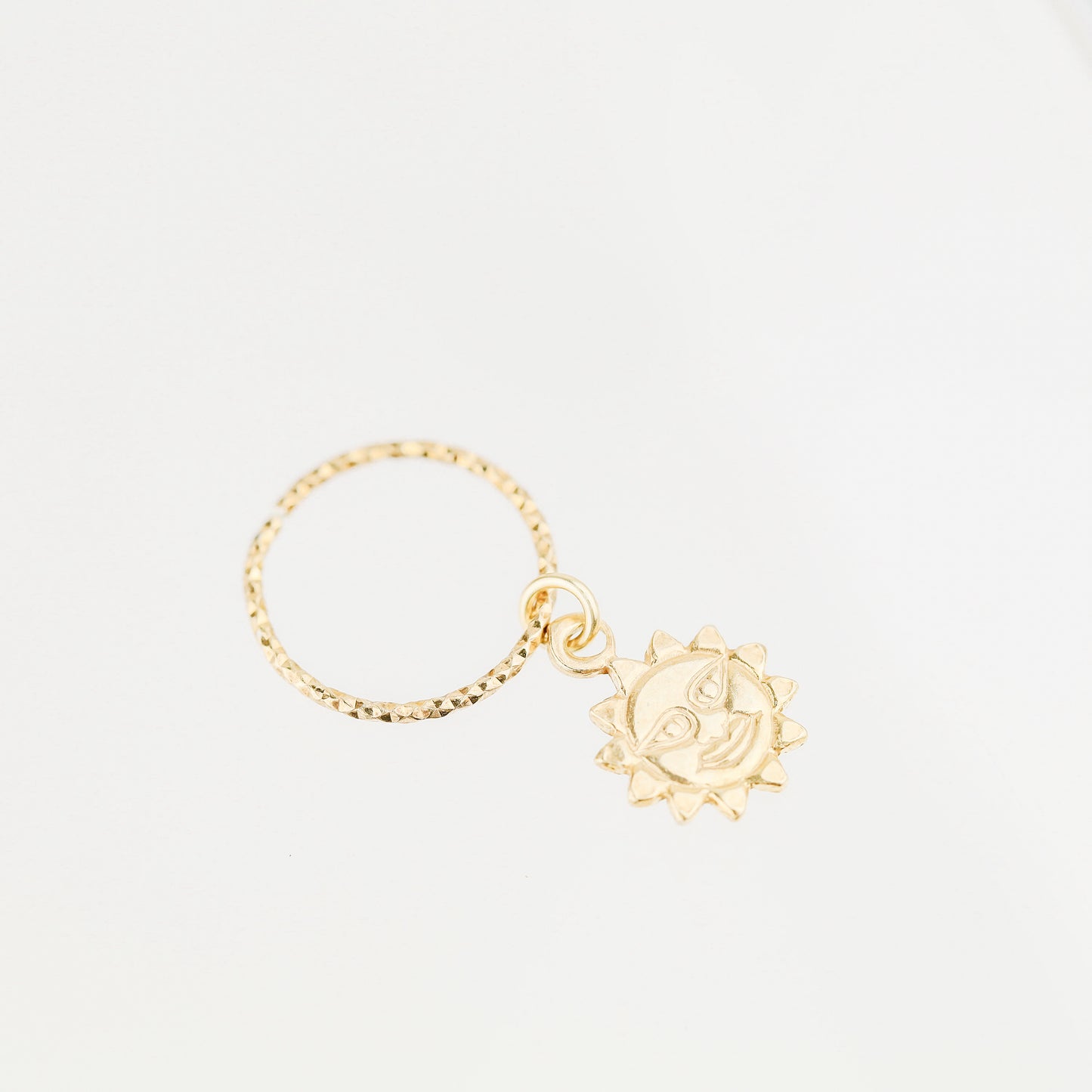 High-resolution shot of a single 18k gold plated sun charm hoop earring on a white background.