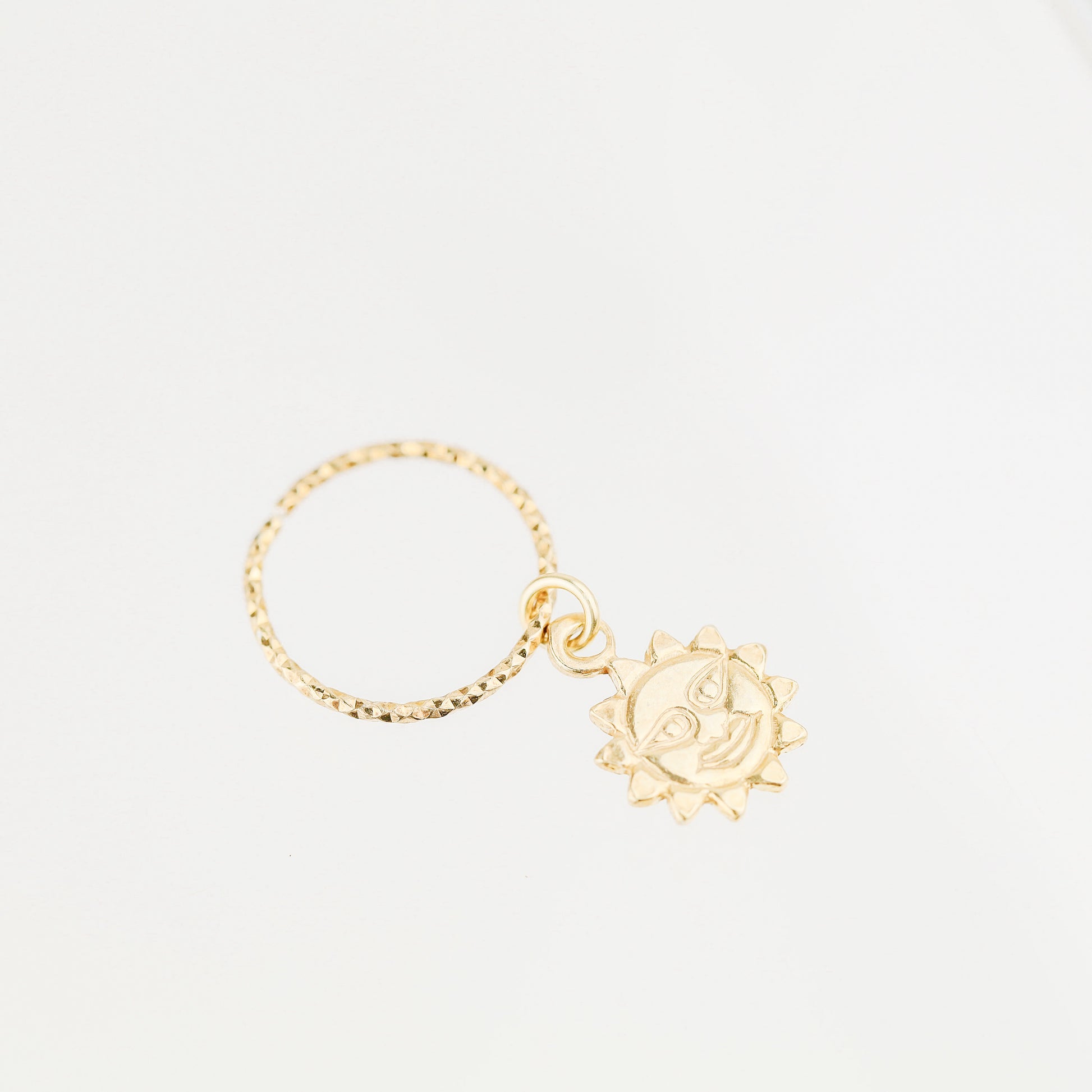 High-resolution shot of a single 18k gold plated sun charm hoop earring on a white background.