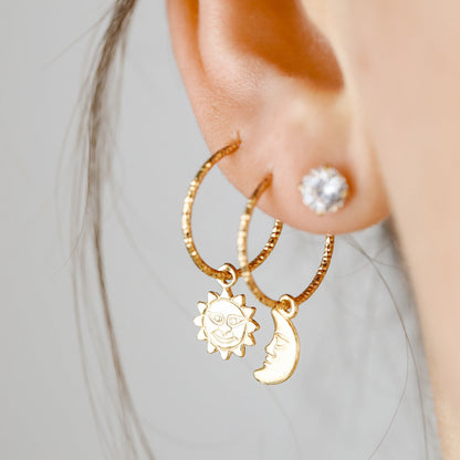 Single 18k yellow gold endless hoop earring featuring a diamond-cut textured finish and a smiling celestial sun charm pendant, shown in a cartilage helix piercing.