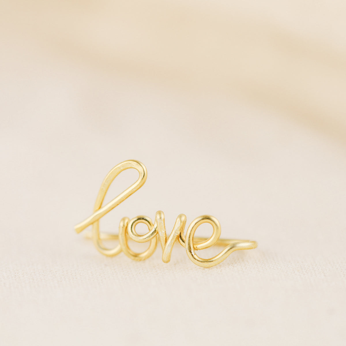 Handmade personalized name ear climber worn across the lobe through one standard piercing, featuring a custom flowing wire script design made with the chosen name or word up to 10 characters, available as a single left ear climber, single right ear climber or pair in solid 925 sterling silver, 14k gold filled and 14k rose gold filled.