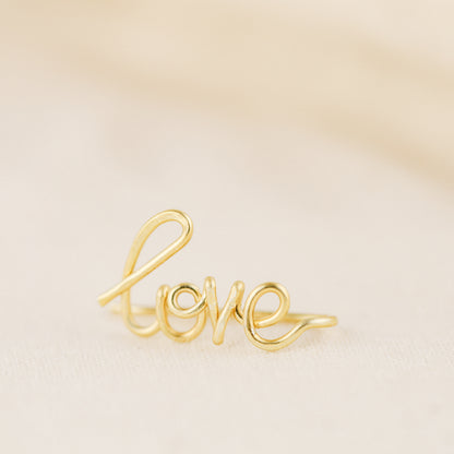 Handmade personalized name ear climber worn across the lobe through one standard piercing, featuring a custom flowing wire script design made with the chosen name or word up to 10 characters, available as a single left ear climber, single right ear climber or pair in solid 925 sterling silver, 14k gold filled and 14k rose gold filled.