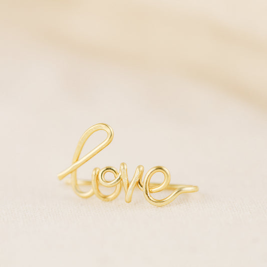 Handmade personalized name ear climber worn across the lobe through one standard piercing, featuring a custom flowing wire script design made with the chosen name or word up to 10 characters, available as a single left ear climber, single right ear climber or pair in solid 925 sterling silver, 14k gold filled and 14k rose gold filled.