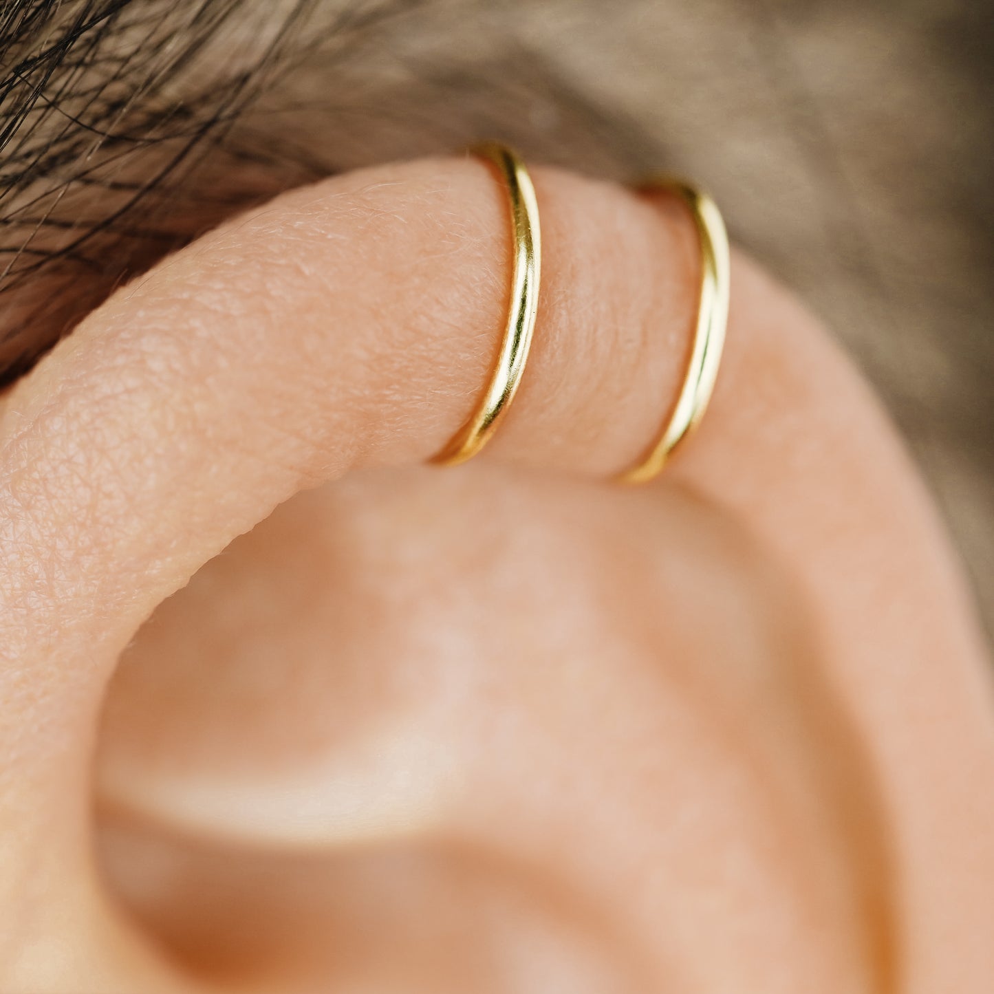 No-piercing double line and criss cross helix ear cuff shown on the upper ear, with smooth and diamond cut finish options for cartilage styling.