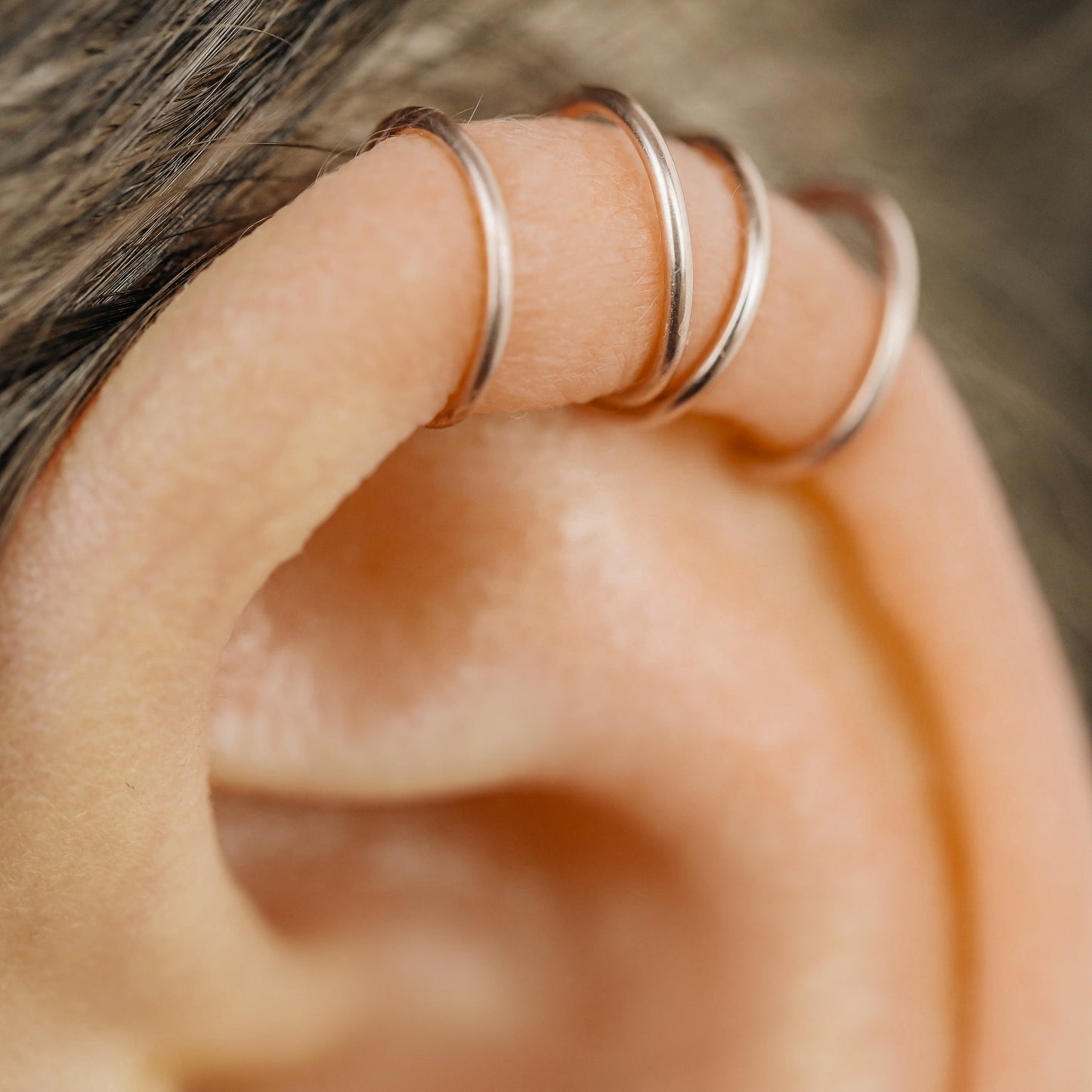 No-piercing double line and criss cross helix ear cuff shown on the upper ear, with smooth and diamond cut finish options for cartilage styling.