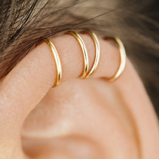 Handmade set of gold criss cross and double line helix ear cuffs for non-pierced ears, adjustable minimalist jewelry available in 12k gold filled, sterling silver, and 16 gauge black aluminum.