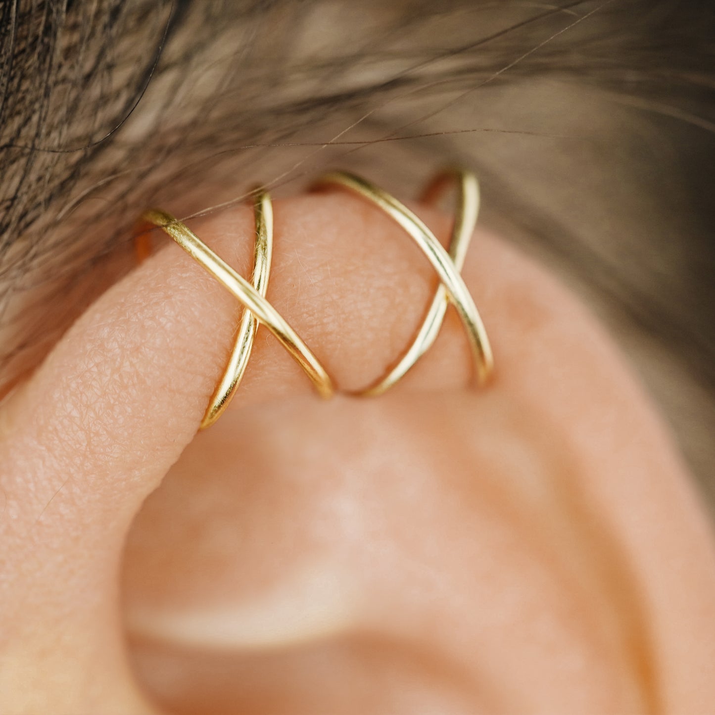 No-piercing double line and criss cross helix ear cuff shown on the upper ear, with smooth and diamond cut finish options for cartilage styling.