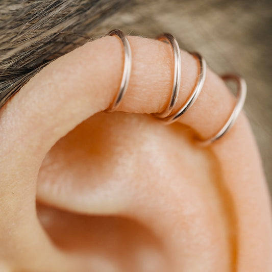 Handmade set of gold criss cross and double line helix ear cuffs for non-pierced ears, adjustable minimalist jewelry available in 12k gold filled, sterling silver, and 16 gauge black aluminum.