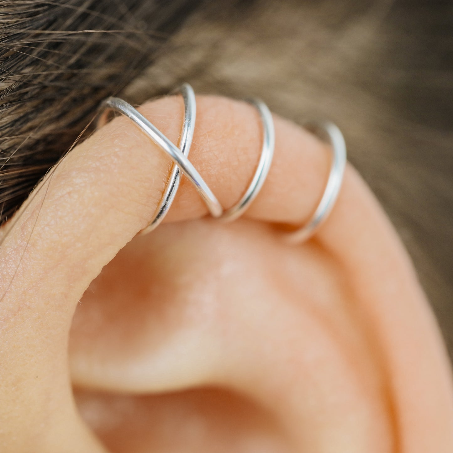 No-piercing double line and criss cross helix ear cuff shown on the upper ear, with smooth and diamond cut finish options for cartilage styling.